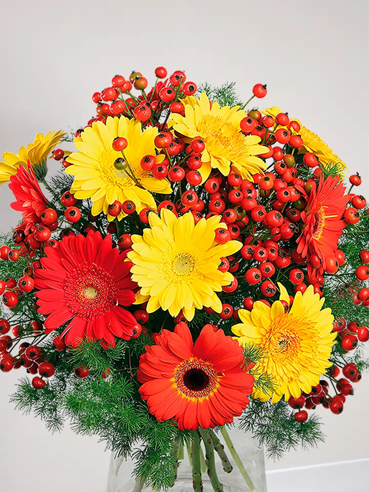 Bouquet di gerbere arancio e gialle con bacche rosse